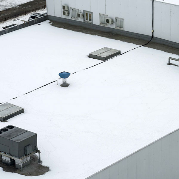 Top view of a commercial roof that recently had a white TPO single-ply roofing system installed on it